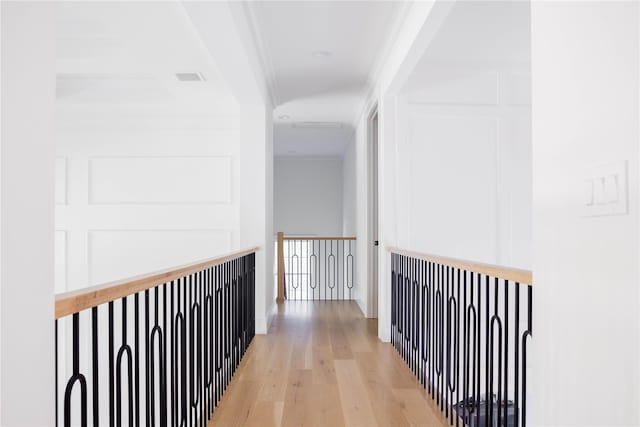 corridor with crown molding and light wood-type flooring