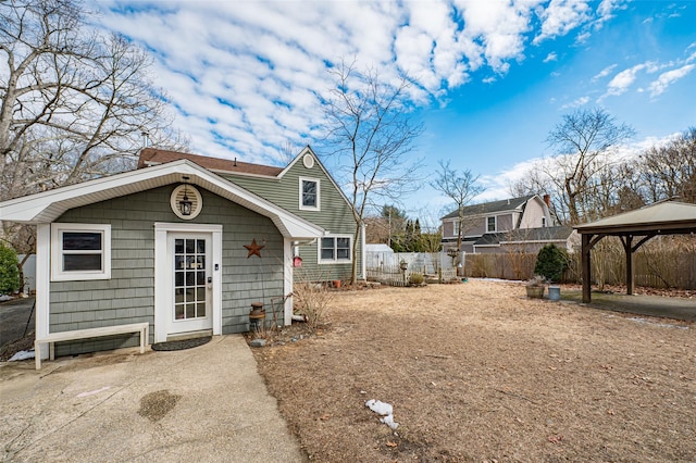 rear view of property featuring a gazebo and fence