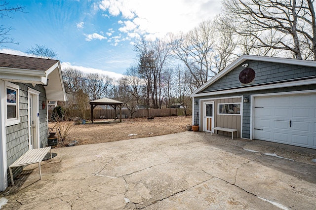 garage featuring driveway and fence