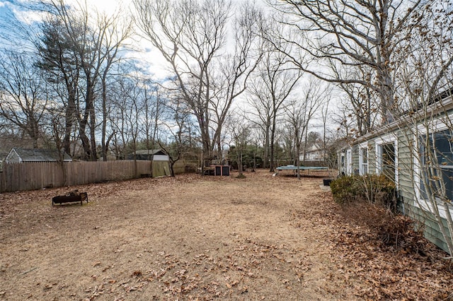 view of yard with a trampoline and fence