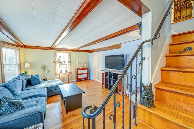 living room featuring stairs, wood finished floors, and beam ceiling