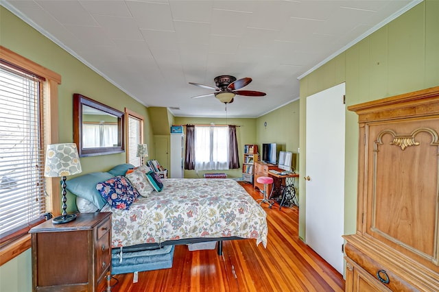 bedroom featuring crown molding, ceiling fan, and wood finished floors