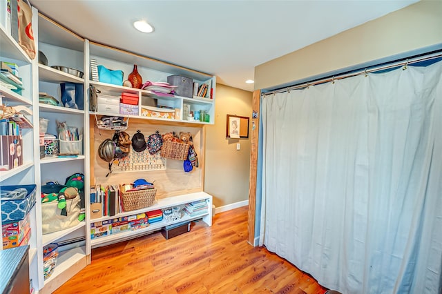 interior space featuring recessed lighting, baseboards, and wood finished floors