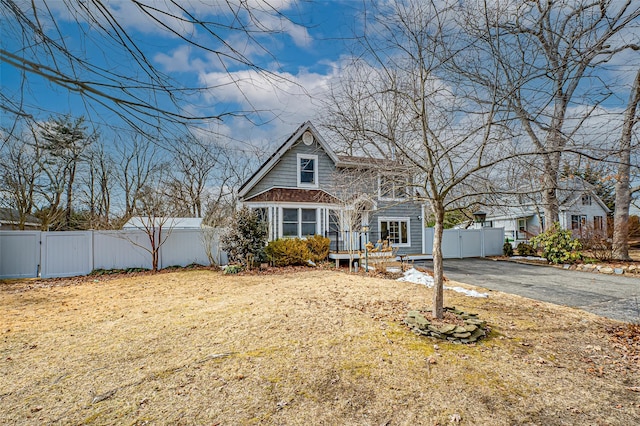 shingle-style home with driveway, a gate, and fence