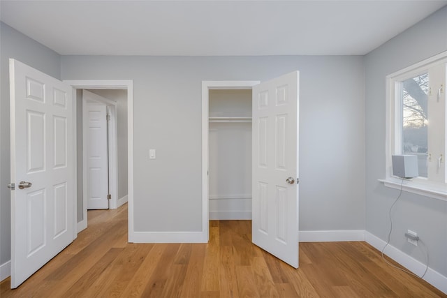 unfurnished bedroom with light hardwood / wood-style floors and a closet