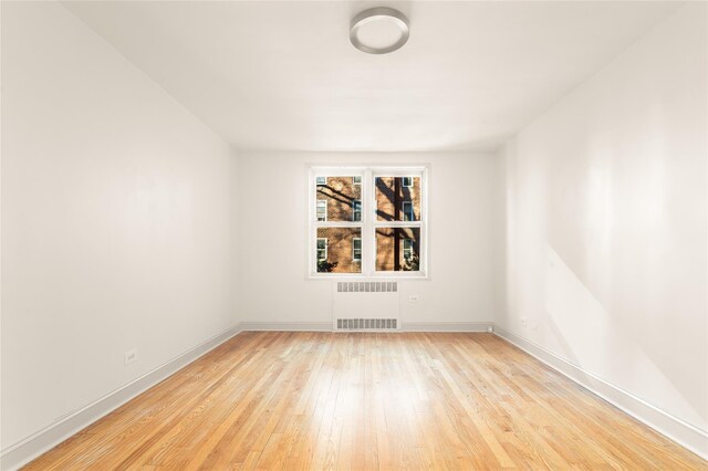 empty room with radiator and light wood-type flooring