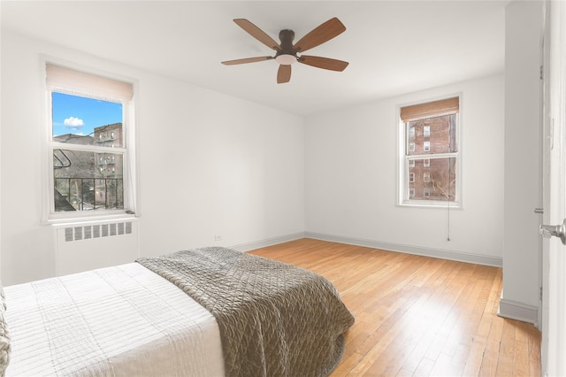 bedroom featuring ceiling fan, wood-type flooring, and radiator