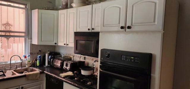 kitchen featuring sink, black appliances, and white cabinets