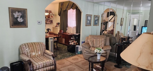 living area featuring arched walkways and crown molding