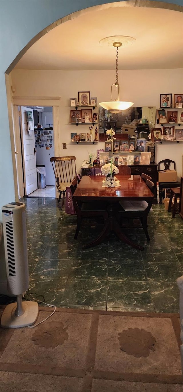 dining space featuring marble finish floor and arched walkways