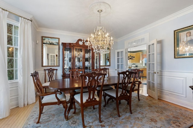 dining space with light hardwood / wood-style flooring, ornamental molding, french doors, and plenty of natural light