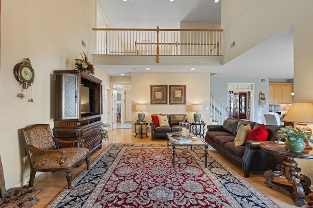 living room with a high ceiling and light hardwood / wood-style floors