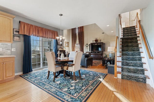 dining space with an inviting chandelier and light hardwood / wood-style floors