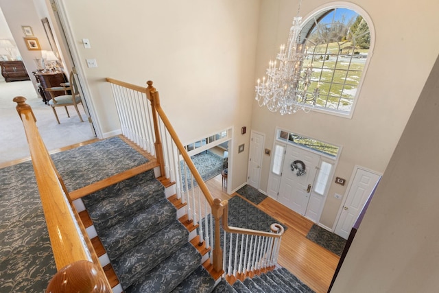 foyer entrance featuring hardwood / wood-style floors, a high ceiling, and a notable chandelier