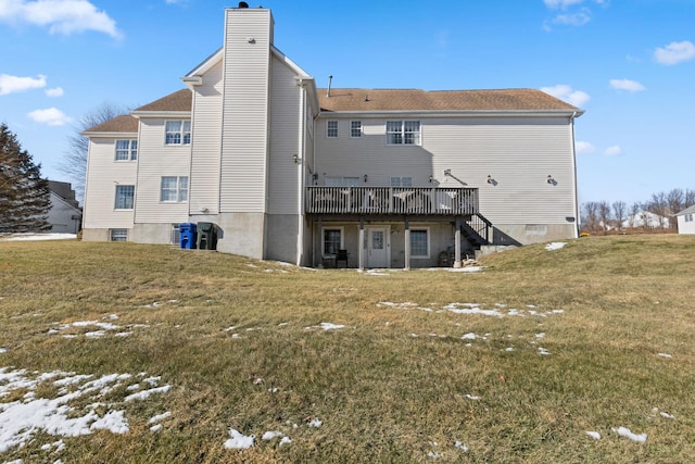 back of property featuring a wooden deck and a yard