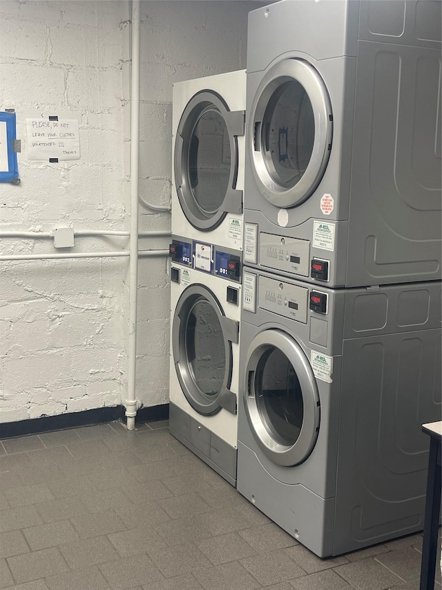 washroom featuring stacked washer / drying machine