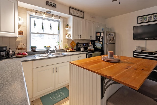 kitchen featuring sink, appliances with stainless steel finishes, tasteful backsplash, white cabinets, and wood counters