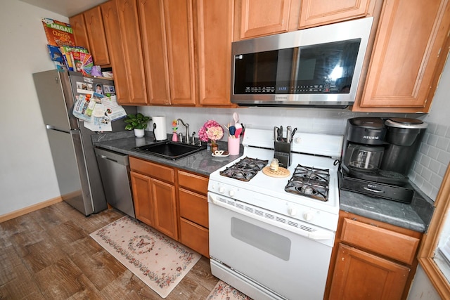 kitchen featuring dark hardwood / wood-style flooring, sink, tasteful backsplash, and stainless steel appliances