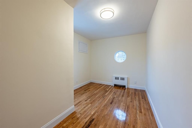 empty room with radiator and light hardwood / wood-style flooring