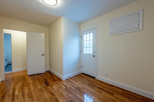 foyer with a baseboard radiator and light hardwood / wood-style flooring