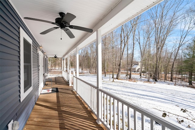 snow covered deck featuring ceiling fan and a porch