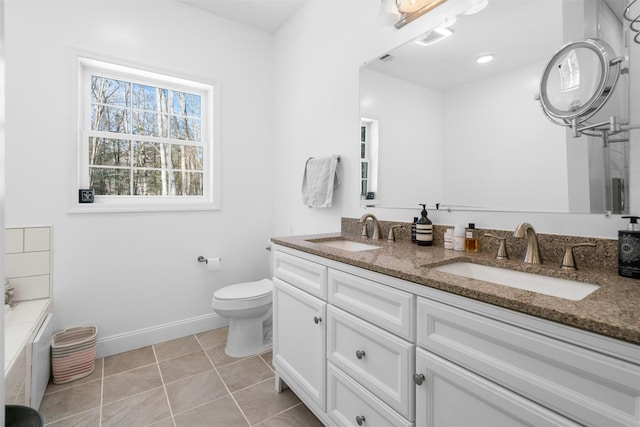 bathroom featuring vanity, tile patterned flooring, a bathing tub, and toilet