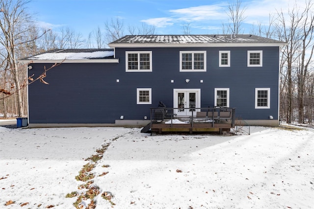 snow covered back of property featuring a deck and french doors