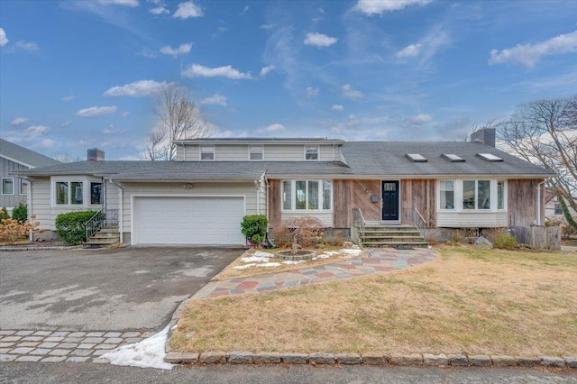 front facade with a garage and a front lawn