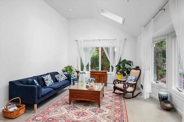 living room featuring lofted ceiling with skylight, light hardwood / wood-style flooring, and a wealth of natural light