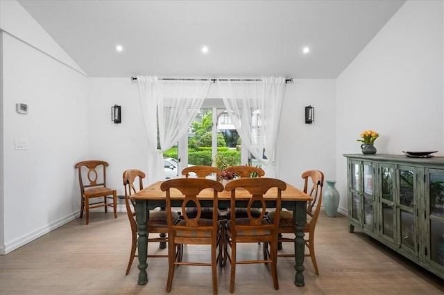 dining space featuring lofted ceiling and light hardwood / wood-style flooring