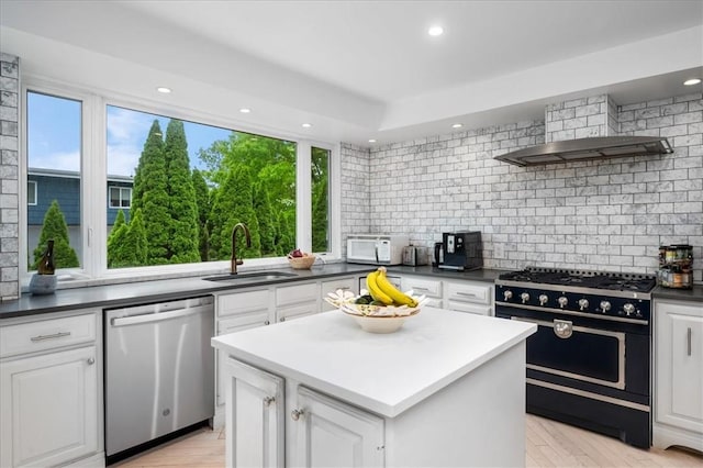 kitchen featuring double oven range, stainless steel dishwasher, sink, and white cabinets