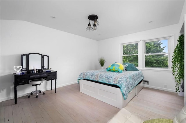 bedroom featuring vaulted ceiling and light hardwood / wood-style floors