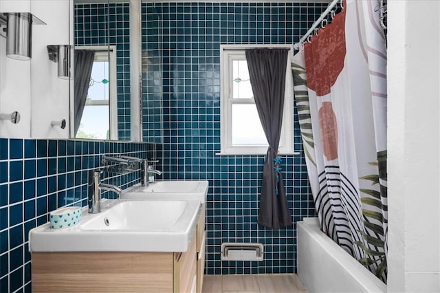 bathroom with vanity, tile walls, and shower / tub combo with curtain