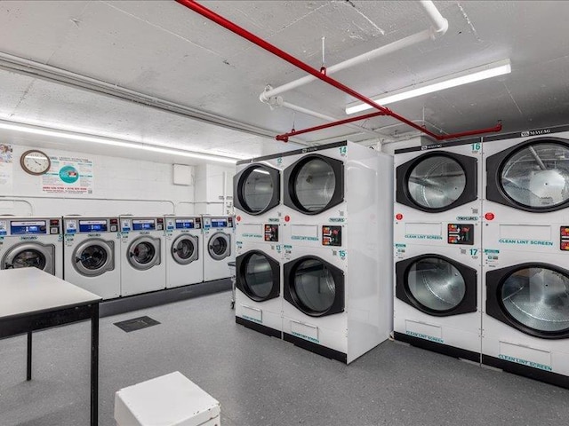 washroom featuring stacked washer / drying machine and washer and clothes dryer