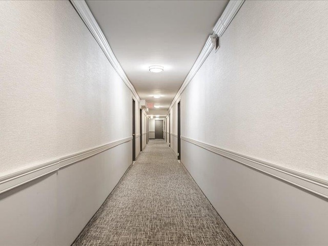 hallway featuring light colored carpet and ornamental molding