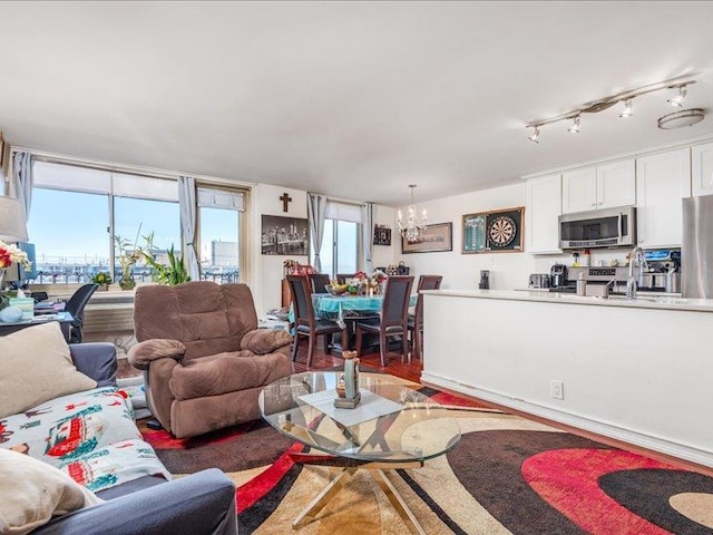 living room with hardwood / wood-style floors, track lighting, and a chandelier