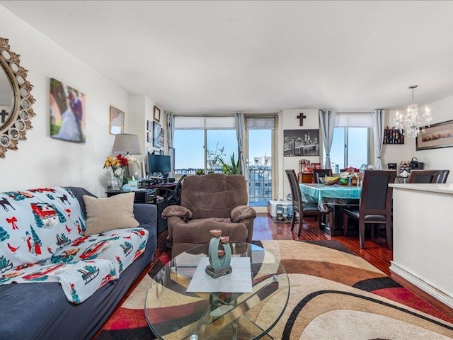 living room featuring dark wood-type flooring, expansive windows, and a notable chandelier