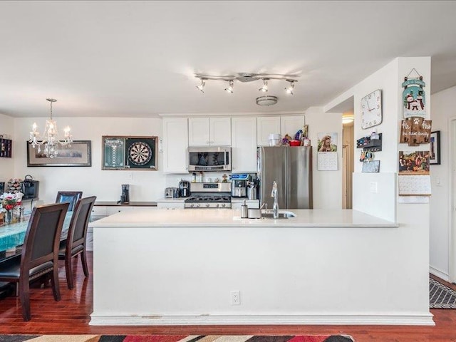 kitchen featuring pendant lighting, white cabinetry, appliances with stainless steel finishes, and sink