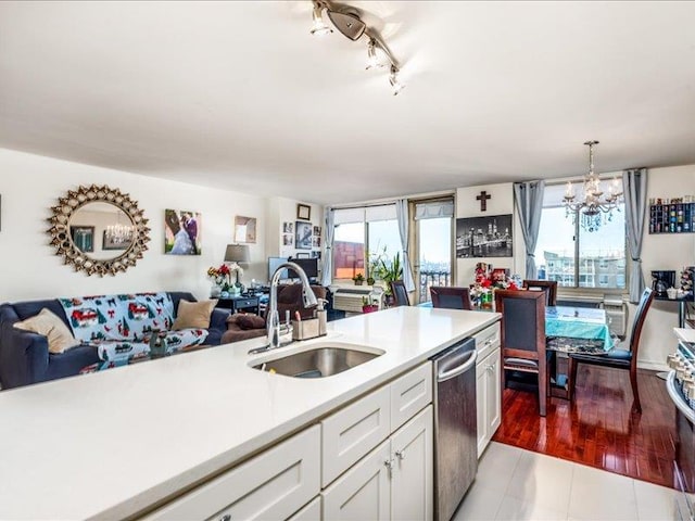 kitchen with sink, decorative light fixtures, a wealth of natural light, and stainless steel dishwasher