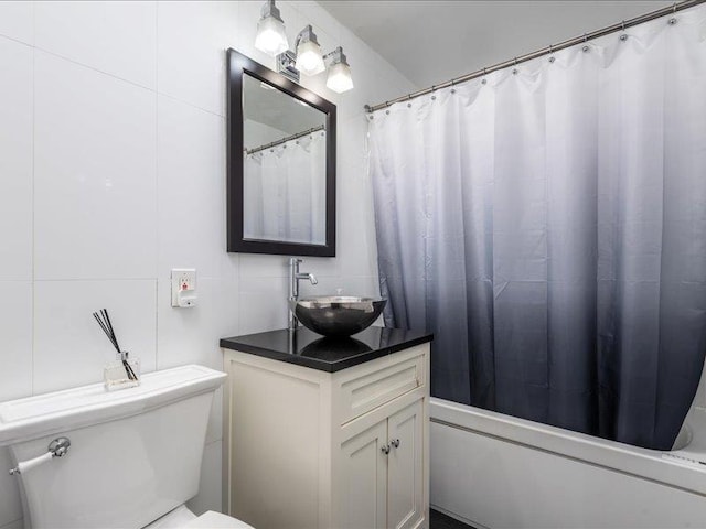 full bathroom with vanity, shower / tub combo, and toilet