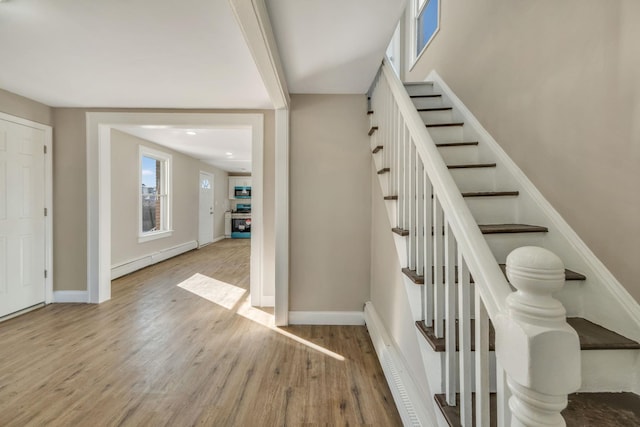 stairway featuring hardwood / wood-style floors and baseboard heating