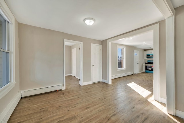 spare room featuring a baseboard radiator and light hardwood / wood-style flooring