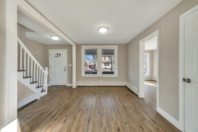 foyer entrance with a healthy amount of sunlight, wood-type flooring, and a baseboard heating unit