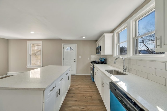 kitchen with sink, white cabinetry, tasteful backsplash, a kitchen island, and black appliances