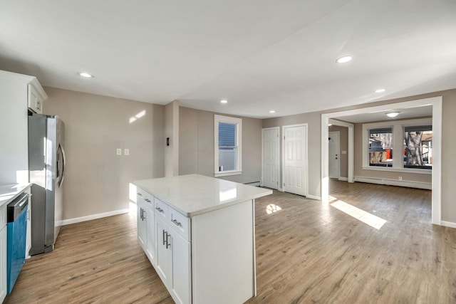 kitchen with white cabinetry, light hardwood / wood-style floors, a center island, and appliances with stainless steel finishes