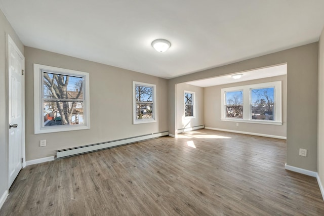 unfurnished room featuring hardwood / wood-style flooring and a baseboard radiator