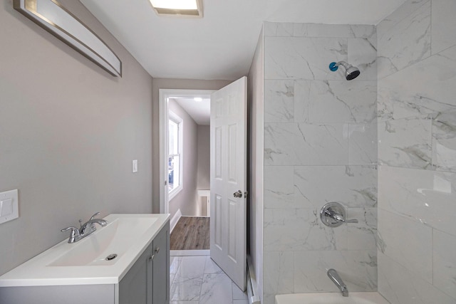 bathroom featuring tiled shower / bath combo and vanity