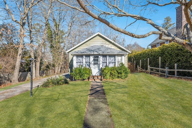 bungalow-style home featuring an outbuilding and a front yard