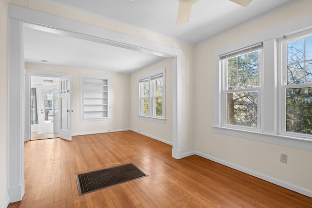 unfurnished room with built in shelves, ceiling fan, and light hardwood / wood-style flooring