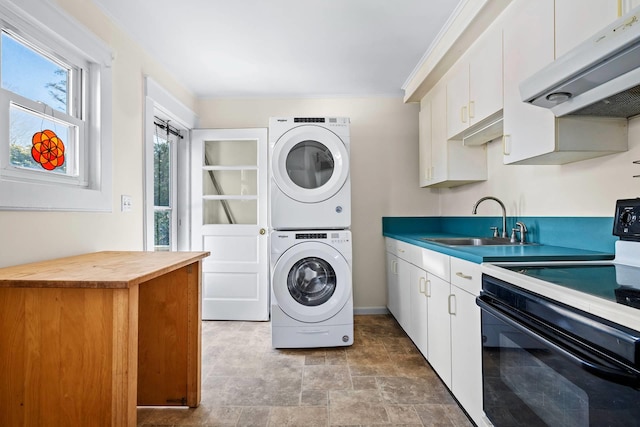 washroom featuring stacked washing maching and dryer, sink, and crown molding